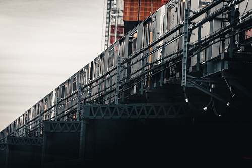shipping container gray train under gray clouds at daytime metro